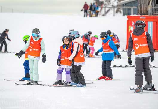 Kinder auf Skis im Schnee