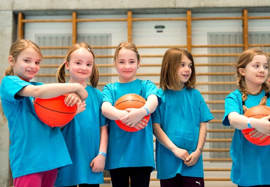 Mädchen spielen Basketball